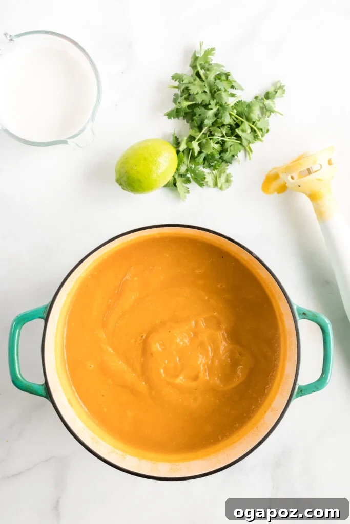 Velvety Butternut Curry Dream 4 Curried Butternut Squash Soup simmering in a large pot on the stove, showing its rich, orange color before blending.