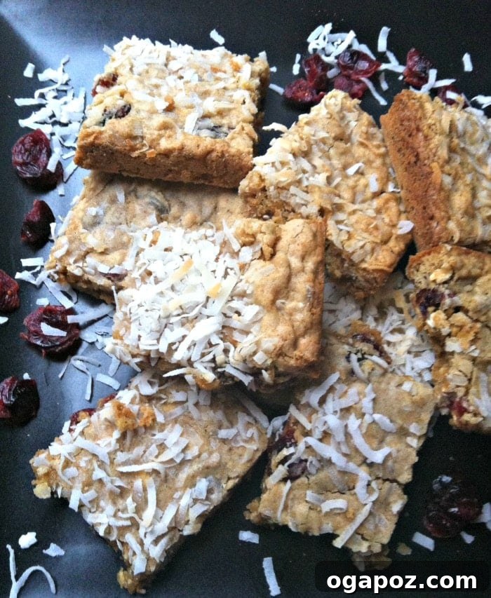 Kid-Approved Chewy Coconut Cranberry Granola Bars 2 Delicious Chewy Coconut Cranberry Oatmeal Bars stacked on a white plate, ready to be enjoyed