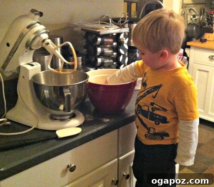 Kid-Approved Chewy Coconut Cranberry Granola Bars 4 A young child, Will, actively mixing ingredients in a bowl during a family cooking session