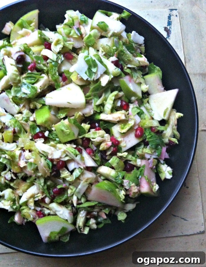 Crisp Shaved Brussels Sprout Salad with Apple and Pomegranate 4 Close-up of healthy Shaved Brussels Sprout Salad with Apple and Pomegranate, highlighting texture