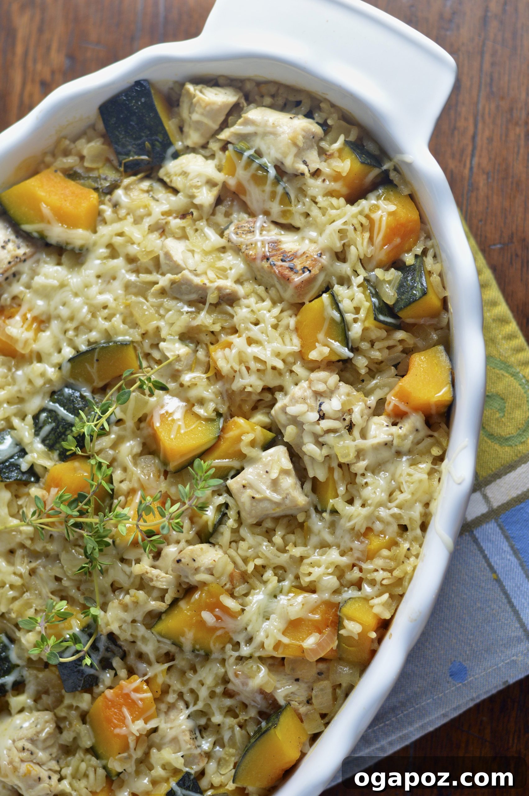 Creamy Kabocha Squash Risotto with Baked Chicken 2 A large white casserole dish filled with golden-brown Baked Chicken Kabocha Squash Risotto, garnished with fresh herbs, ready to be served for a comforting fall meal.