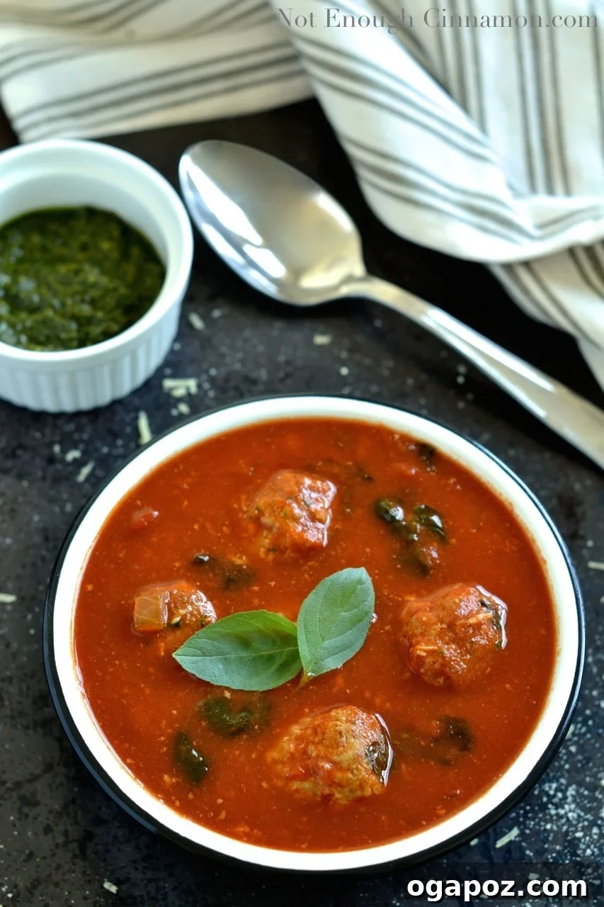 Vibrant Spinach and Tomato Comfort 4 Spinach and Tomato Soup with a swirl of basil pesto on top, showcasing the vibrant colors and fresh flavors.