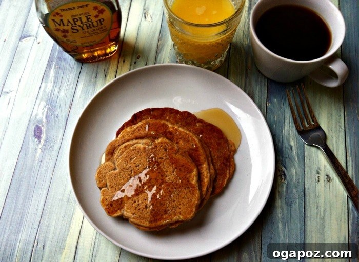 Golden Cinnamon Sweet Potato Pancakes 2 Fluffy Sweet Potato Pancakes with a dusting of cinnamon and maple syrup, ready to be served for breakfast.