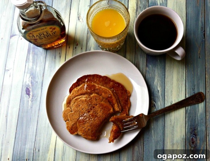 Golden Cinnamon Sweet Potato Pancakes 5 A stack of Sweet Potato Cinnamon Pancakes on a plate, garnished with fresh berries and maple syrup, ready for a healthy breakfast.