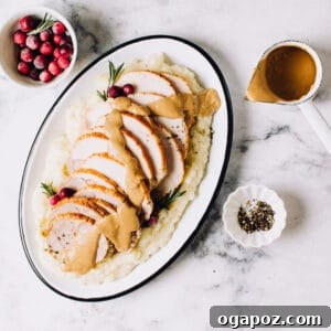 Signature Make Ahead Herbed Peppercorn Brown Gravy 3 A rich, smooth brown gravy poured into a white serving dish, garnished with fresh rosemary.