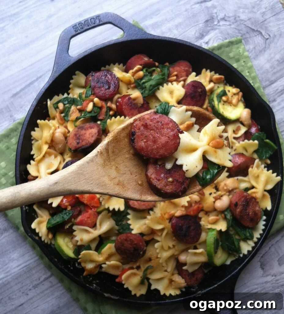 Hearty Smoked Sausage & White Bean Pasta 6 Smoked Sausage Pasta served in a bowl, garnished with fresh herbs and pine nuts.