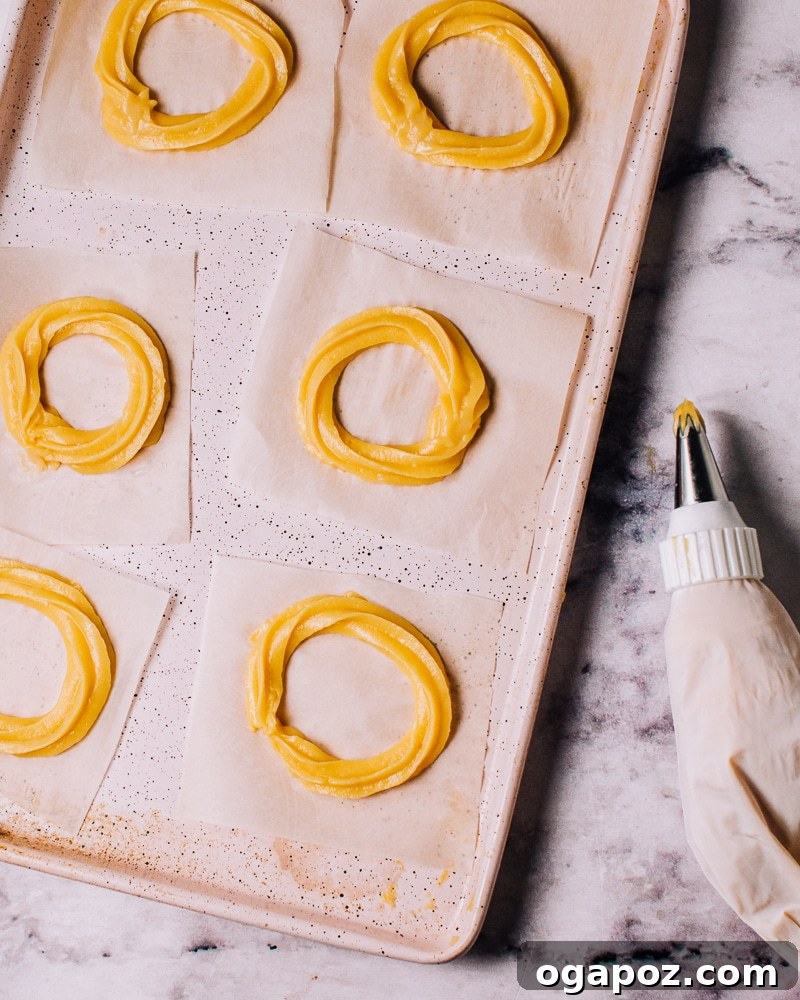 Airy French Delights 13 Piping choux pastry dough into rings on parchment paper for French Crullers.