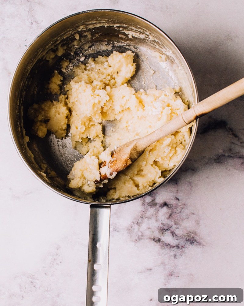 Airy French Delights 7 Stirring the flour into the hot liquid to form the choux pastry dough.