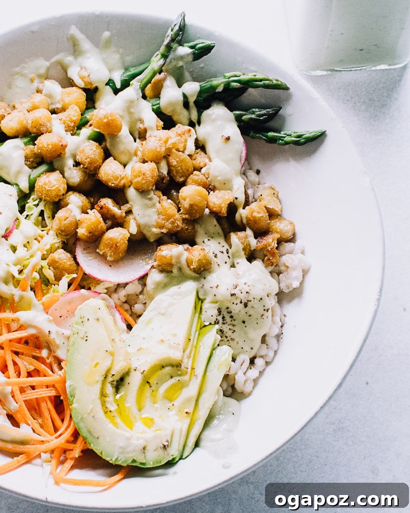 Colorful nourish bowl topped with a generous amount of lemon yogurt sauce, showcasing its versatility.