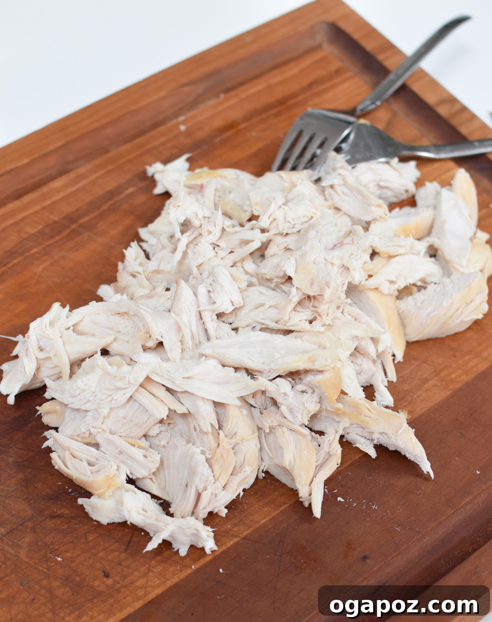 Zesty Lemon Chicken Orzo Soup 7 Cooked chicken breast on a cutting board, ready for shredding or dicing for soup.