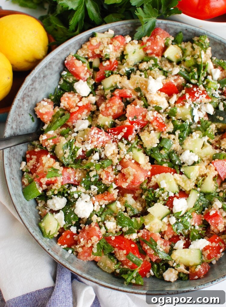 Feta Quinoa Bowl with Tomato Cucumber 2 Tomato Cucumber Feta Quinoa Salad served in a bowl with a spoon, highlighting its fresh ingredients