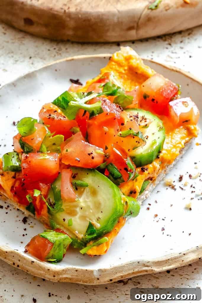 Sun-Kissed Mediterranean Flatbread Pizza 5 A freshly prepared Mediterranean Naan Pizza, glistening with olive oil and vibrant toppings, served on a stylish white plate.