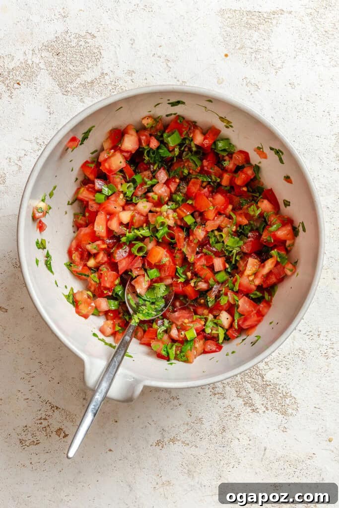 Sun-Kissed Mediterranean Flatbread Pizza 6 A small bowl containing freshly diced tomatoes, chopped parsley, and green onions, mixed with olive oil and lemon juice, ready as a tabbouleh-style salad topping.