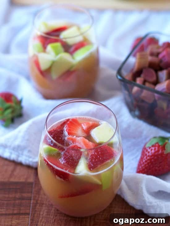 85 Summer Sips to Beat the Heat 11 Strawberry Rhubarb Apple Sangria in a glass pitcher