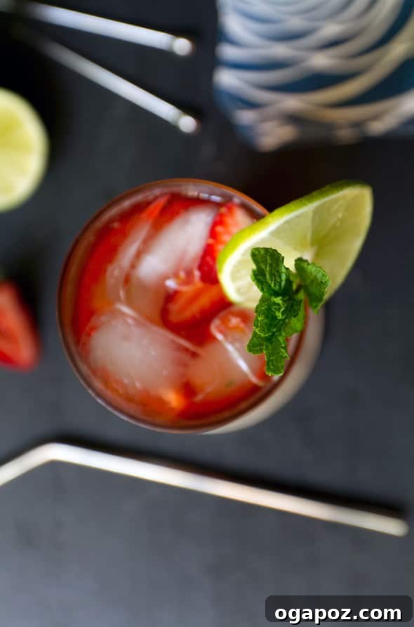 85 Summer Sips to Beat the Heat 13 Strawberry Moscow Mule cocktail in a copper mug with lime and strawberry garnish