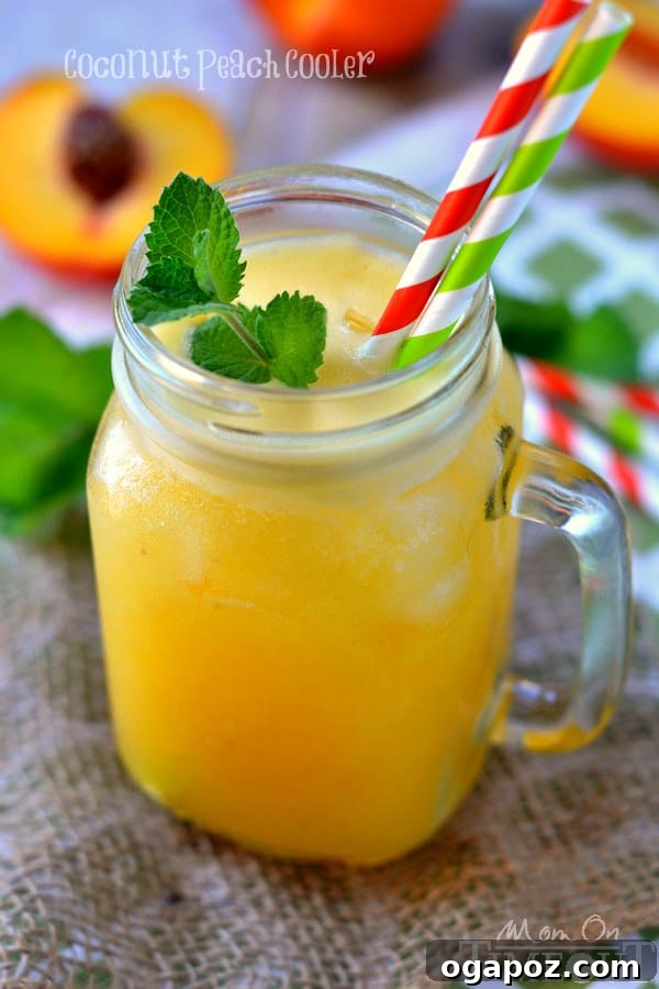85 Summer Sips to Beat the Heat 14 Coconut Peach Cooler in a glass with a peach slice