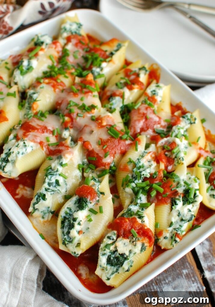 Baked Cheesy Ricotta Shells 3 Close-up of a single Stuffed Shell on a fork, showing the creamy ricotta filling, melted mozzarella, and a hint of fresh chives, ready to be eaten.