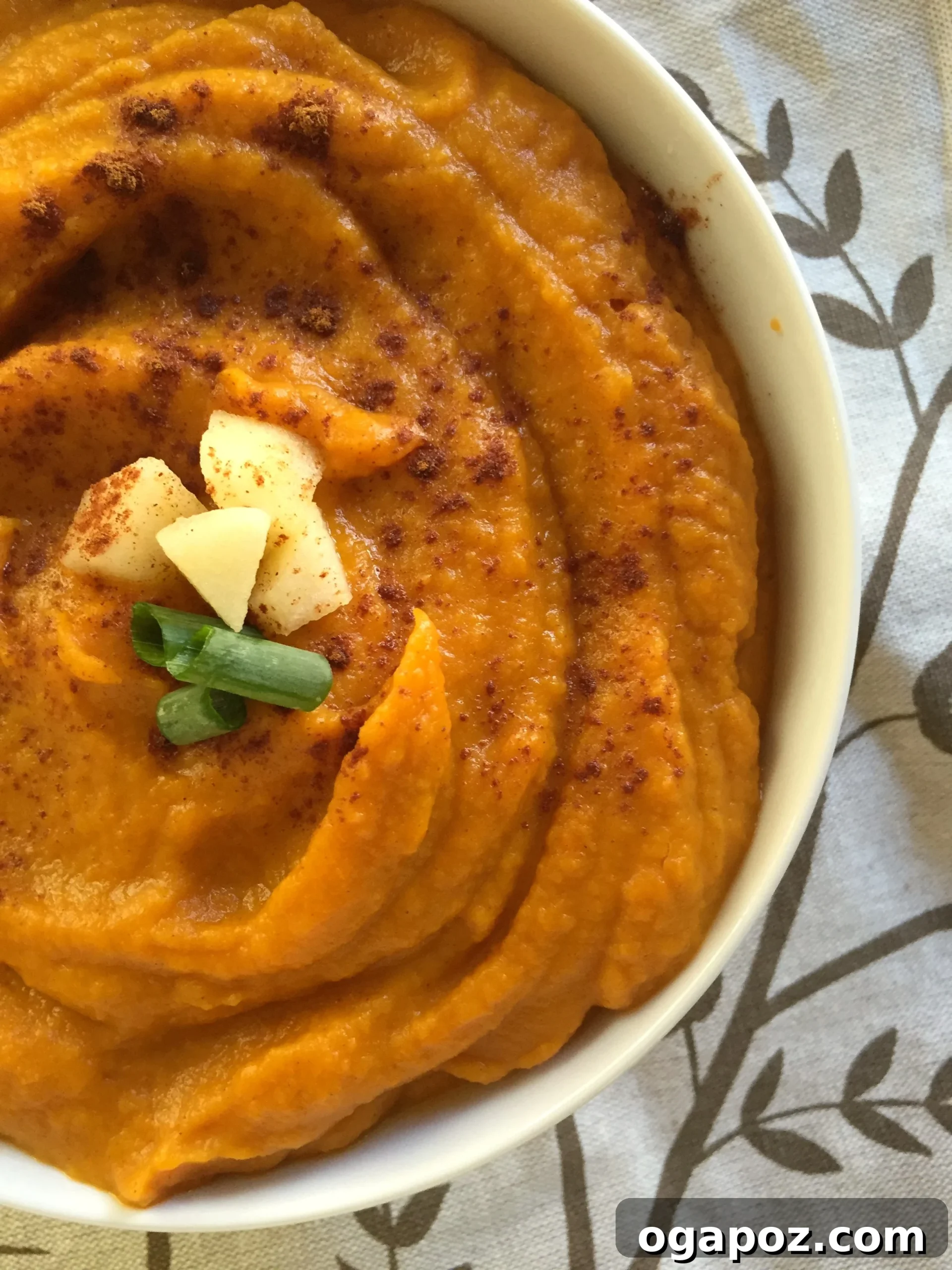 Spiced Harvest Butternut Sweet Potato Apple Soup 2 A beautifully presented bowl of creamy Butternut Squash Sweet Potato Apple Soup, garnished with fresh apple slices and a dash of cinnamon, perfect for a cozy fall day.