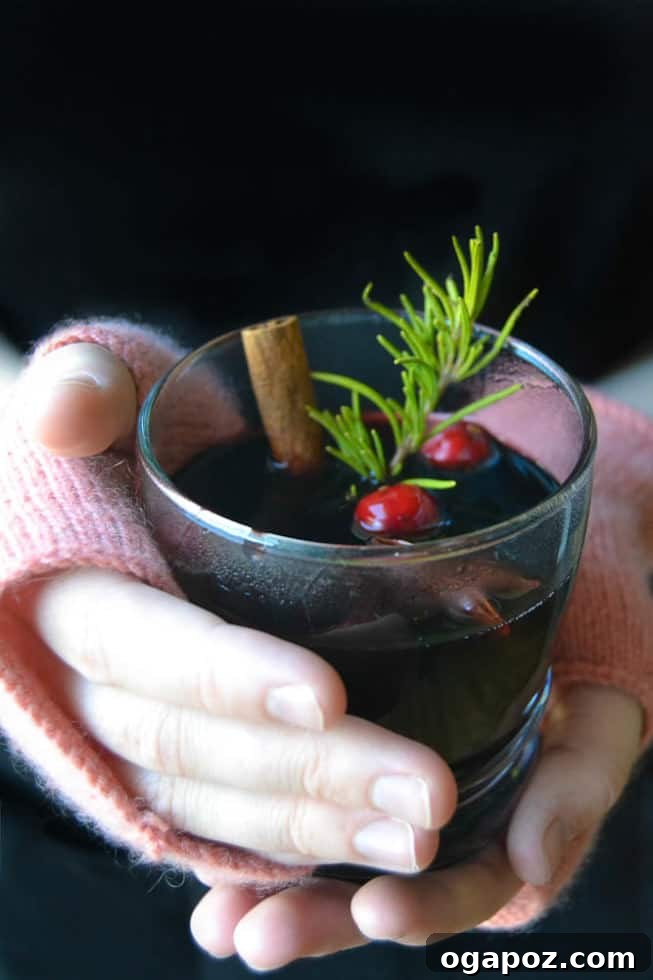Sip into the Season: 41 Festive Drink Creations 3 A close-up of slow cooker mulled wine simmering with whole spices, orange slices, and cranberries, exuding warmth and festive aroma.