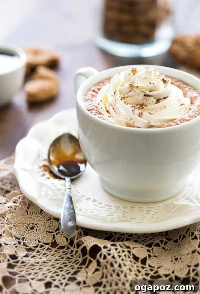 Sip into the Season: 41 Festive Drink Creations 4 A warm ginger snap cookie steamer in a clear mug, topped with whipped cream and a gingerbread man cookie, perfect for a cozy treat.