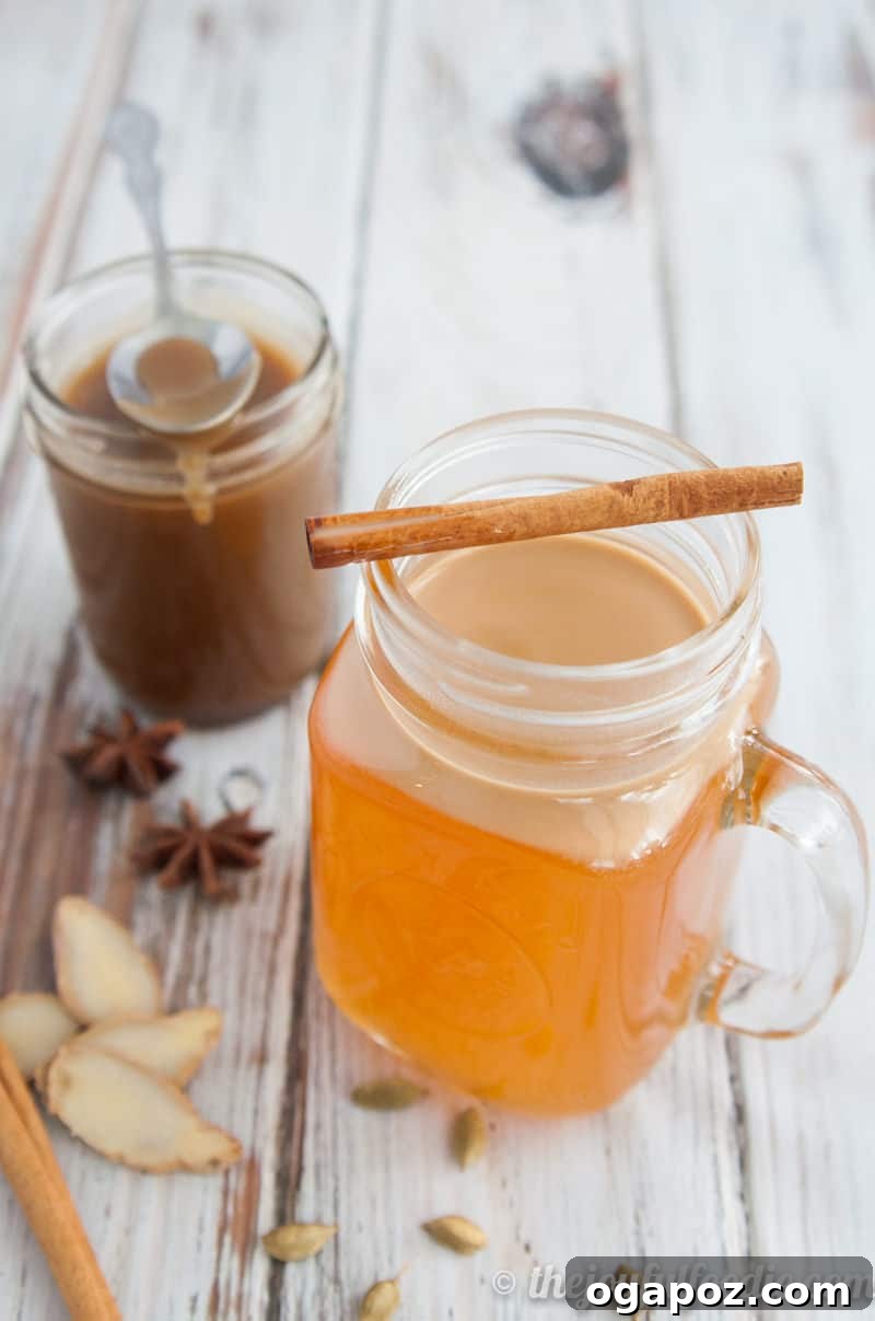 Sip into the Season: 41 Festive Drink Creations 5 Cardamom Spiced Apple Cider in a clear mug, garnished with a cinnamon stick and star anise, evoking warmth.