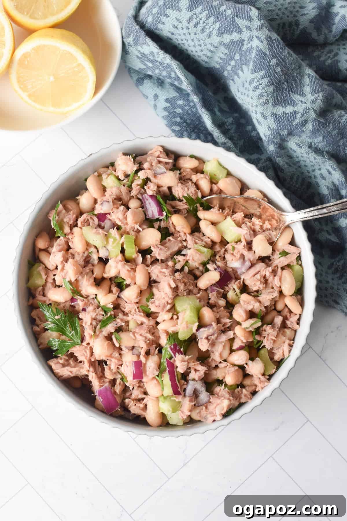 Tuna and White Bean Salad in a white bowl with a fork, ready to be eaten.