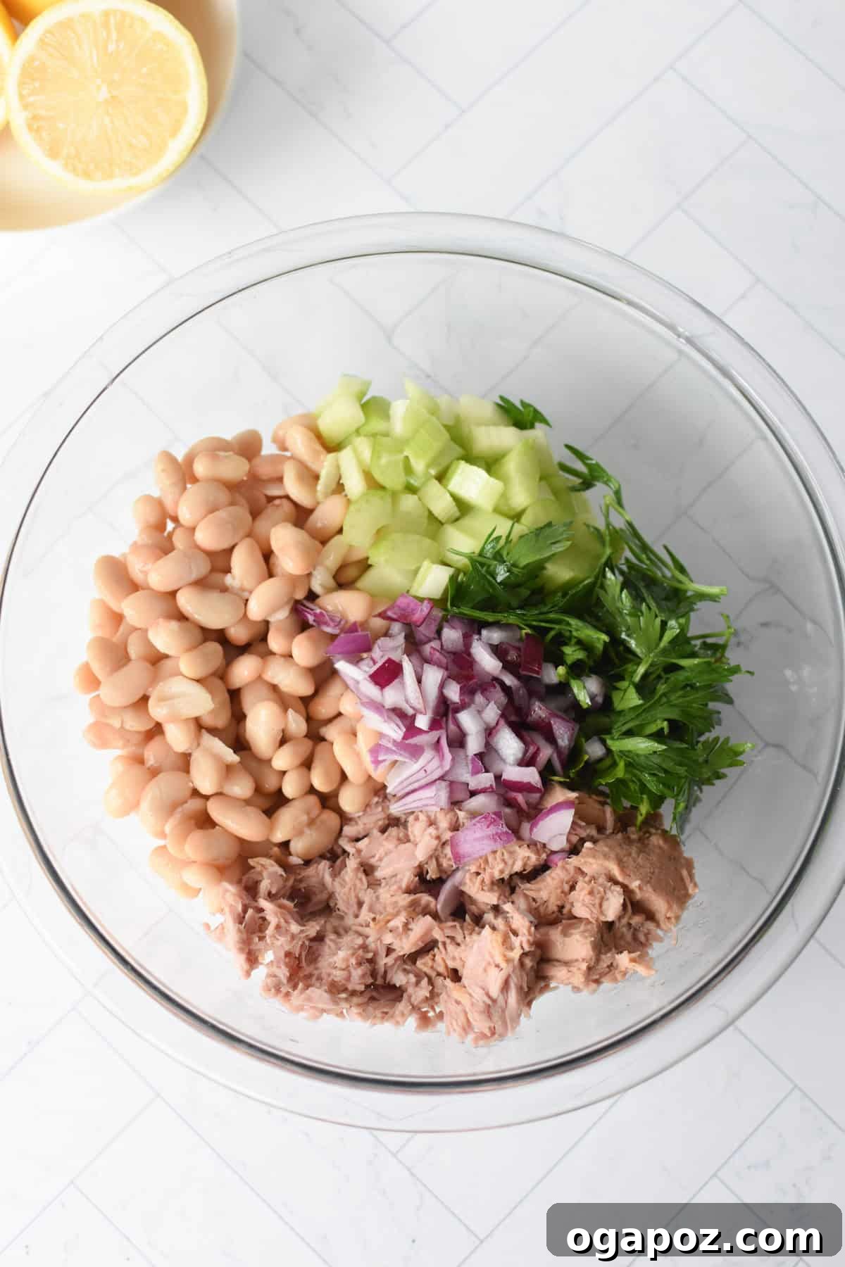 White Bean and Tuna Salad ingredients in a glass bowl, ready to be mixed.