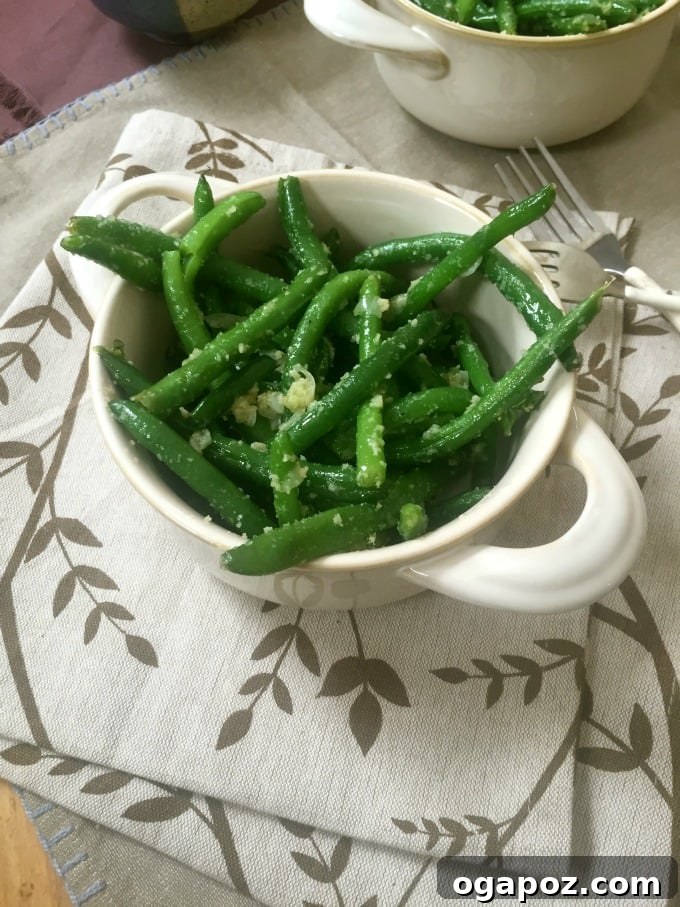 Effortlessly Delicious Garlic Parmesan Green Beans 3 Close-up of steamed green beans being sautéed with garlic and onions in a skillet.