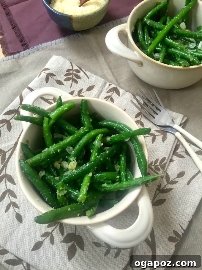 Effortlessly Delicious Garlic Parmesan Green Beans 4 A vibrant plate of Simple Garlic Parmesan Green Beans topped with grated Parmesan cheese.