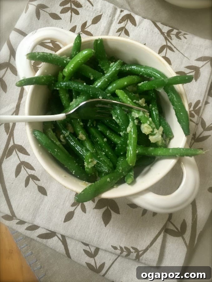 Effortlessly Delicious Garlic Parmesan Green Beans 5 Close-up of butter, minced garlic, and chopped sweet onion sautéing in a hot skillet.