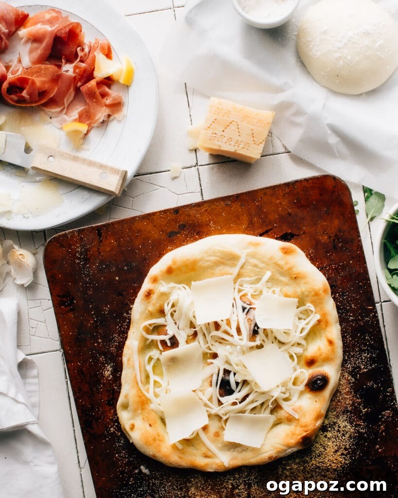 Parma Arugula Elegance 4 Ingredients for Prosciutto di Parma pizza laid out, including a ball of dough, cheese, prosciutto, arugula, garlic, and olive oil.