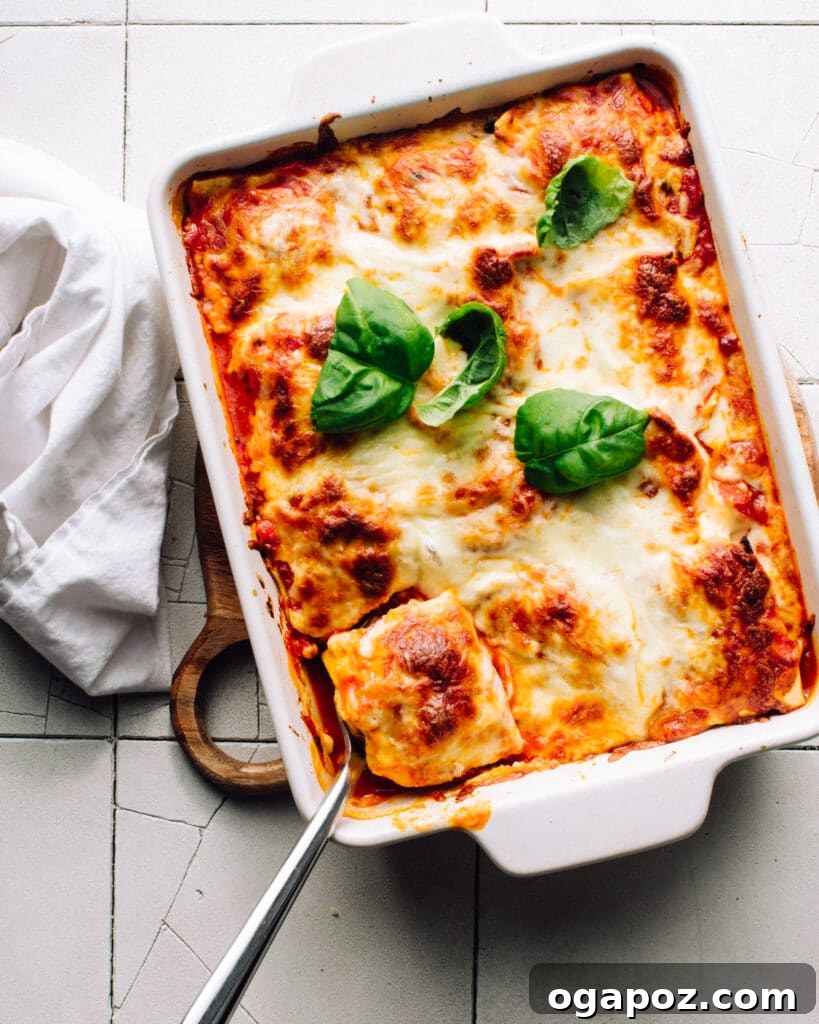 Three-Ingredient Lasagna: Effortless Comfort 4 Scooping out a portion of lazy lasagna made with ravioli, showing the layers of pasta, sauce, and cheese.
