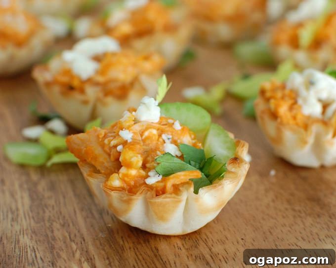 Tangy Buffalo Chicken Hummus Poppers 4 A hand holding a single Buffalo Chicken Hummus Bite, illustrating its perfect bite-sized portion.