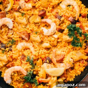 Chorizo paella with chicken and shrimp, beautifully arranged in a pan.
