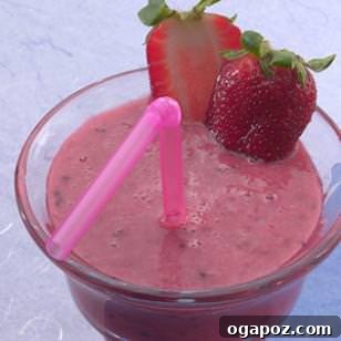 Wake Up Smoothie Freshly blended fruit smoothie in a glass, made with orange juice, banana, berries, and yogurt