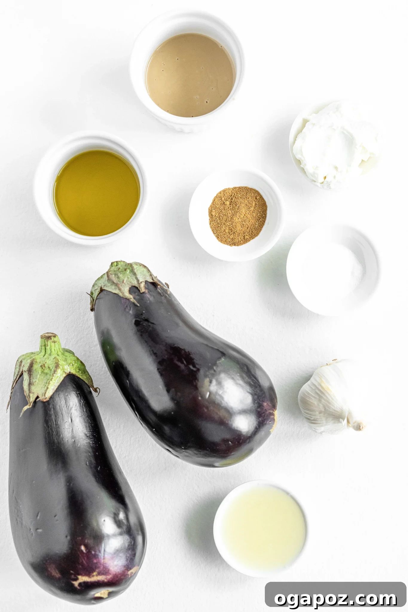 Smoky Roasted Eggplant Dip 3 A flat lay of Baba Ghanoush ingredients including eggplant, tahini, lemon, garlic, and olive oil.