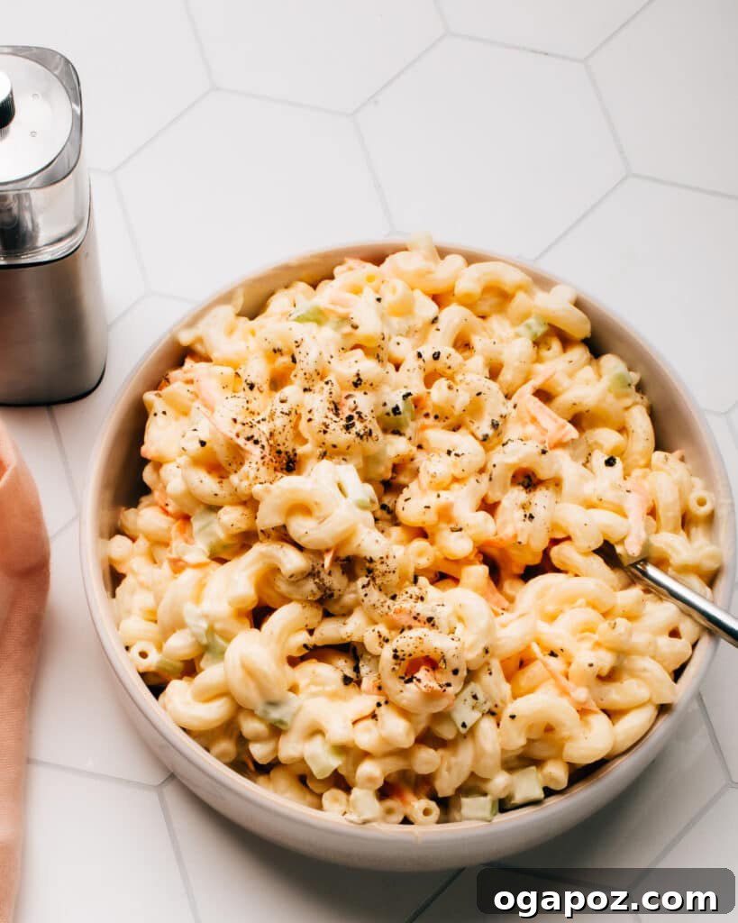 The Ultimate Macaroni Salad 2 A vibrant, creamy macaroni salad in a serving bowl, garnished with fresh herbs, ready to be enjoyed.