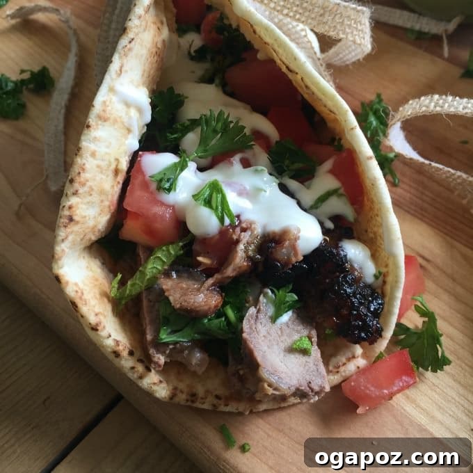 Zesty Mediterranean Steak Wraps with Cool Mint Yogurt 2 Grilled Mediterranean Steak Pita Wrap with Mint Yogurt Sauce on a rustic cutting board, showcasing fresh ingredients.