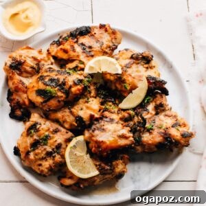 Grilled Honey Mustard Chicken on a plate with lemon slices.