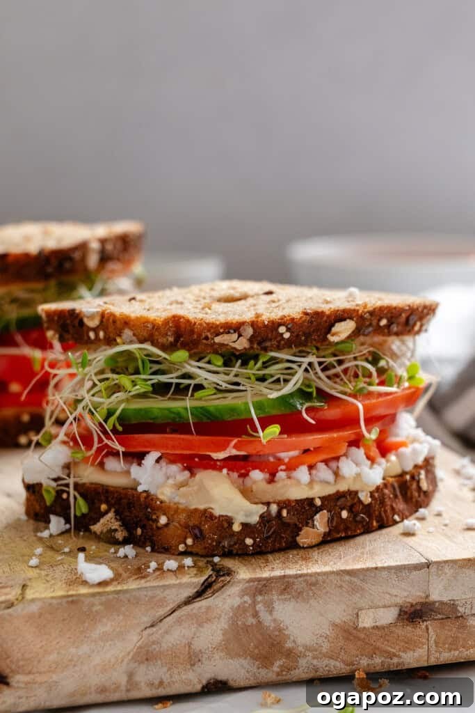 Mediterranean Vegetable Sandwich freshly cut on a wooden cutting board.