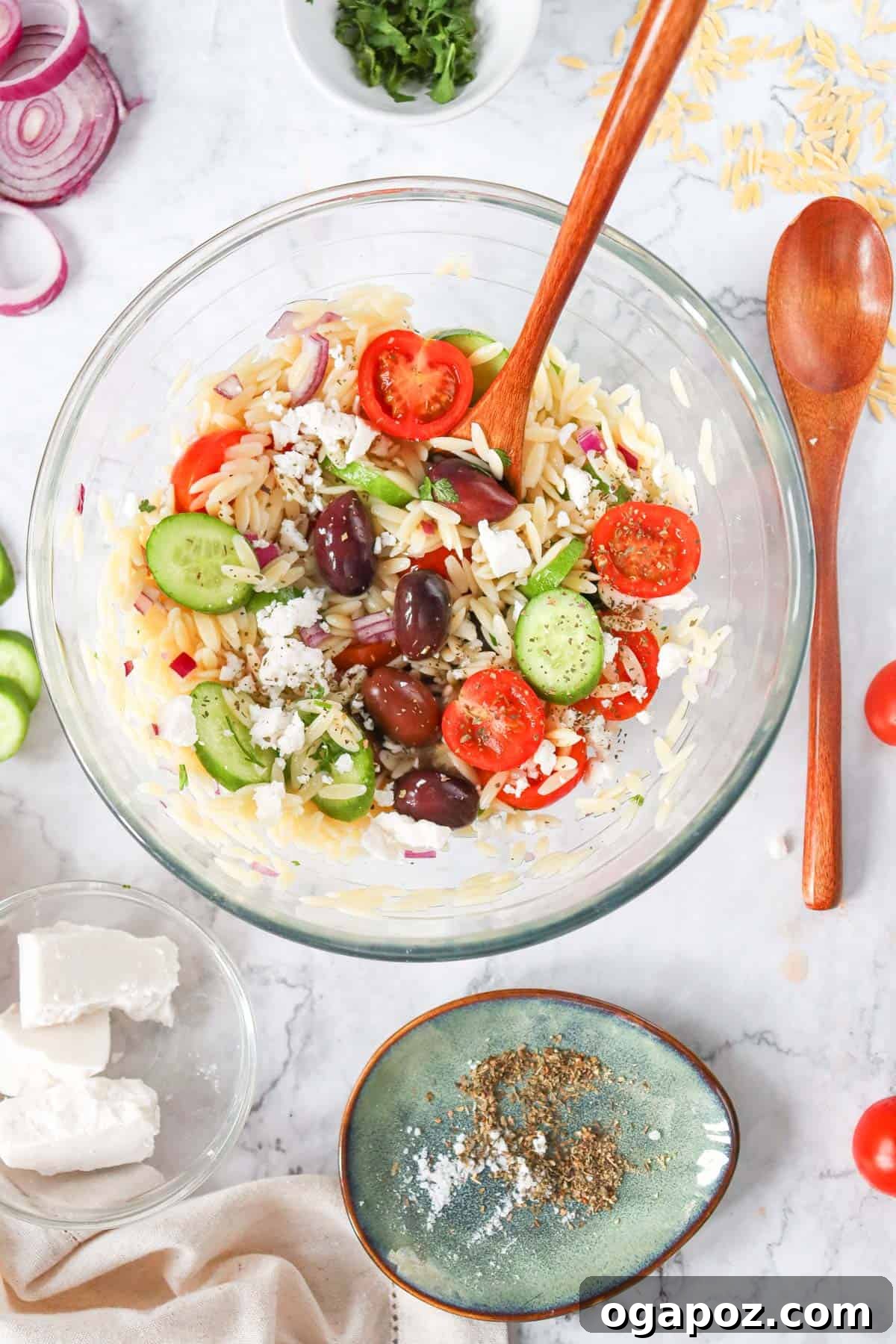 Vibrant Grecian Orzo 8 A serving of Greek Orzo Pasta Salad in a bowl with a spoon, ready to be enjoyed.