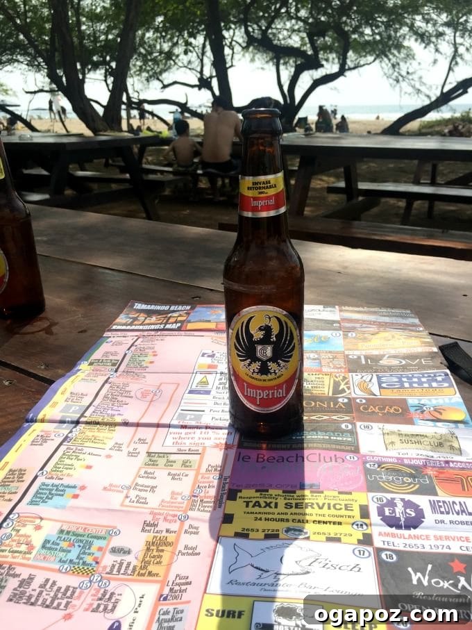 Tamarindo: Costa Rica's Pacific Paradise 8 Cold bottle of Imperial beer on a wooden table with a blurred beach background