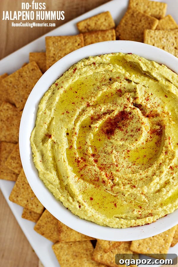 Beyond the Bowl: 12 Exciting Hummus Recipes 13 A bowl of vibrant Jalapeño Hummus, featuring sliced jalapeños and a sprinkle of spices.