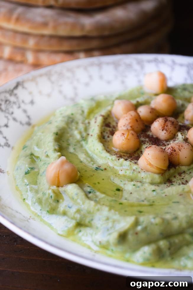 Beyond the Bowl: 12 Exciting Hummus Recipes 5 A bowl of vibrant green Cilantro Hummus, garnished with fresh cilantro leaves.