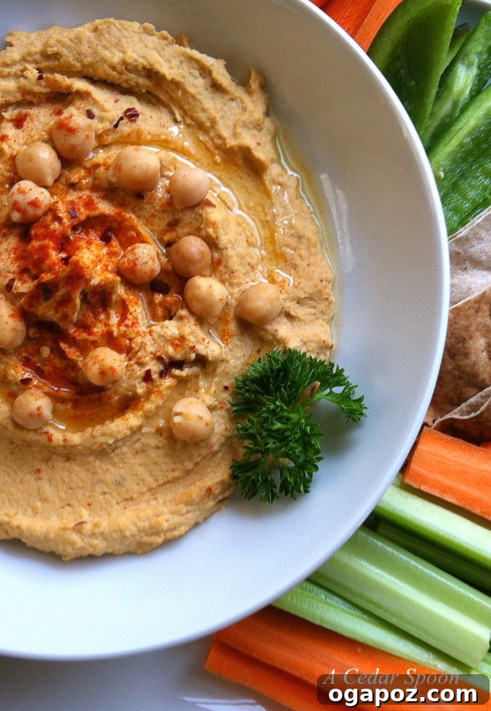 Beyond the Bowl: 12 Exciting Hummus Recipes 8 A close-up of a bowl of spicy hummus, topped with red pepper flakes and a swirl of olive oil.