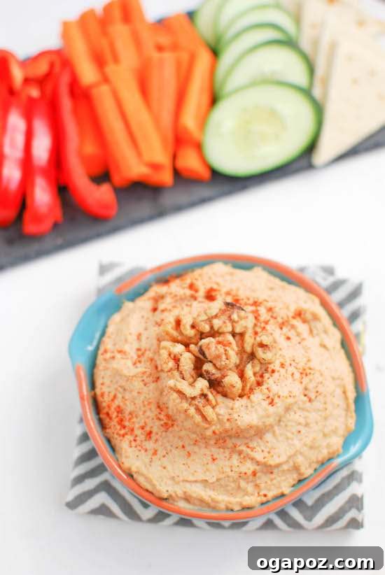 Beyond the Bowl: 12 Exciting Hummus Recipes 9 A bowl of rich and creamy Spicy Roasted Garlic and Walnut Hummus, garnished with fresh herbs and walnuts.