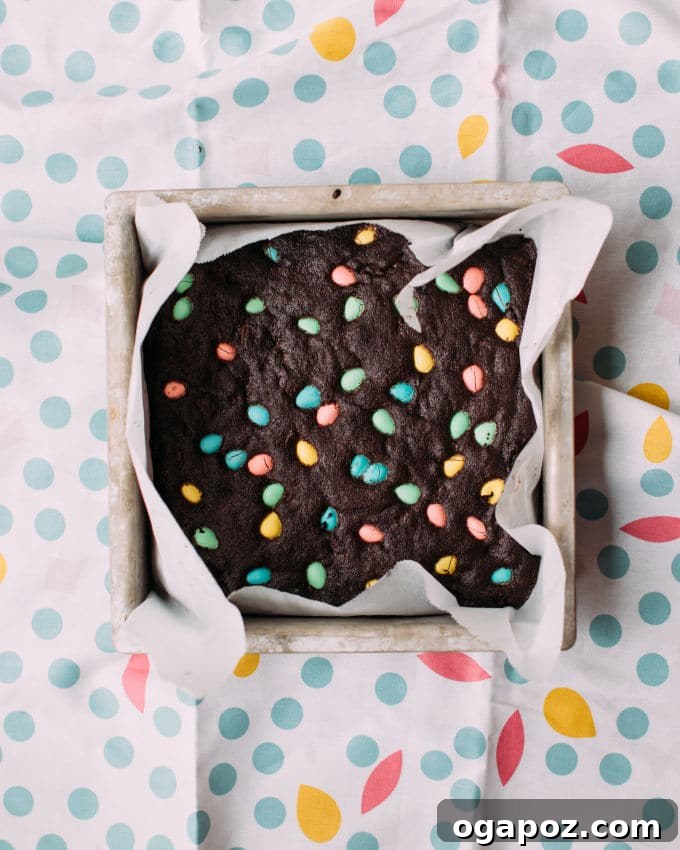 Hoppy Easter Brownies 3 Rich brownie batter being spread evenly into a parchment-lined baking pan.