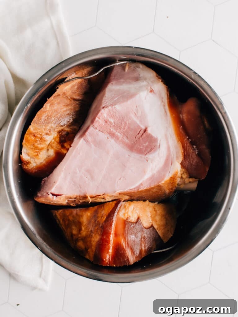 A smoked ham carefully placed inside a pressure cooker on top of the trivet, ready for cooking.