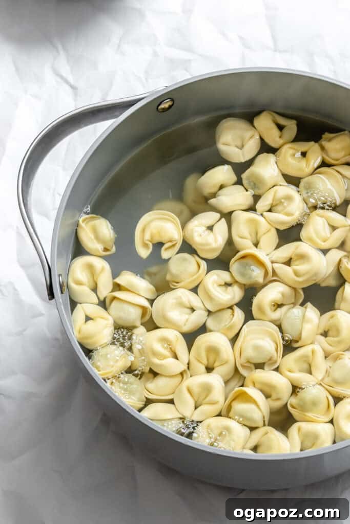 Tortellini boiling gently in a large pot of salted water on the stovetop.