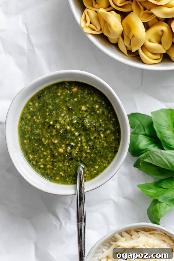 A small bowl filled with vibrant green homemade pesto sauce, indicating it's ready for use.
